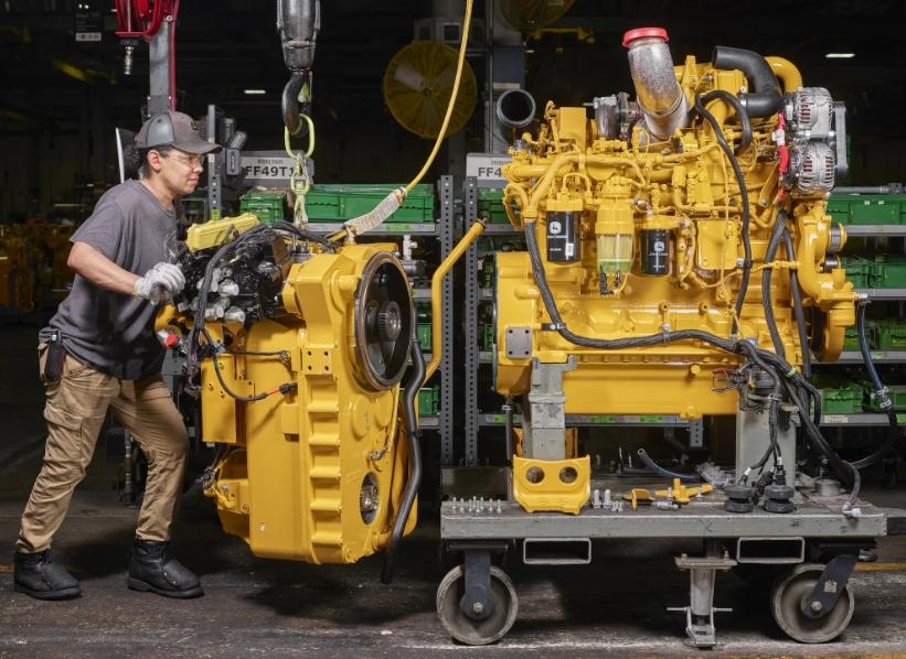 a John Deere motor grader engine and transmission in a factory